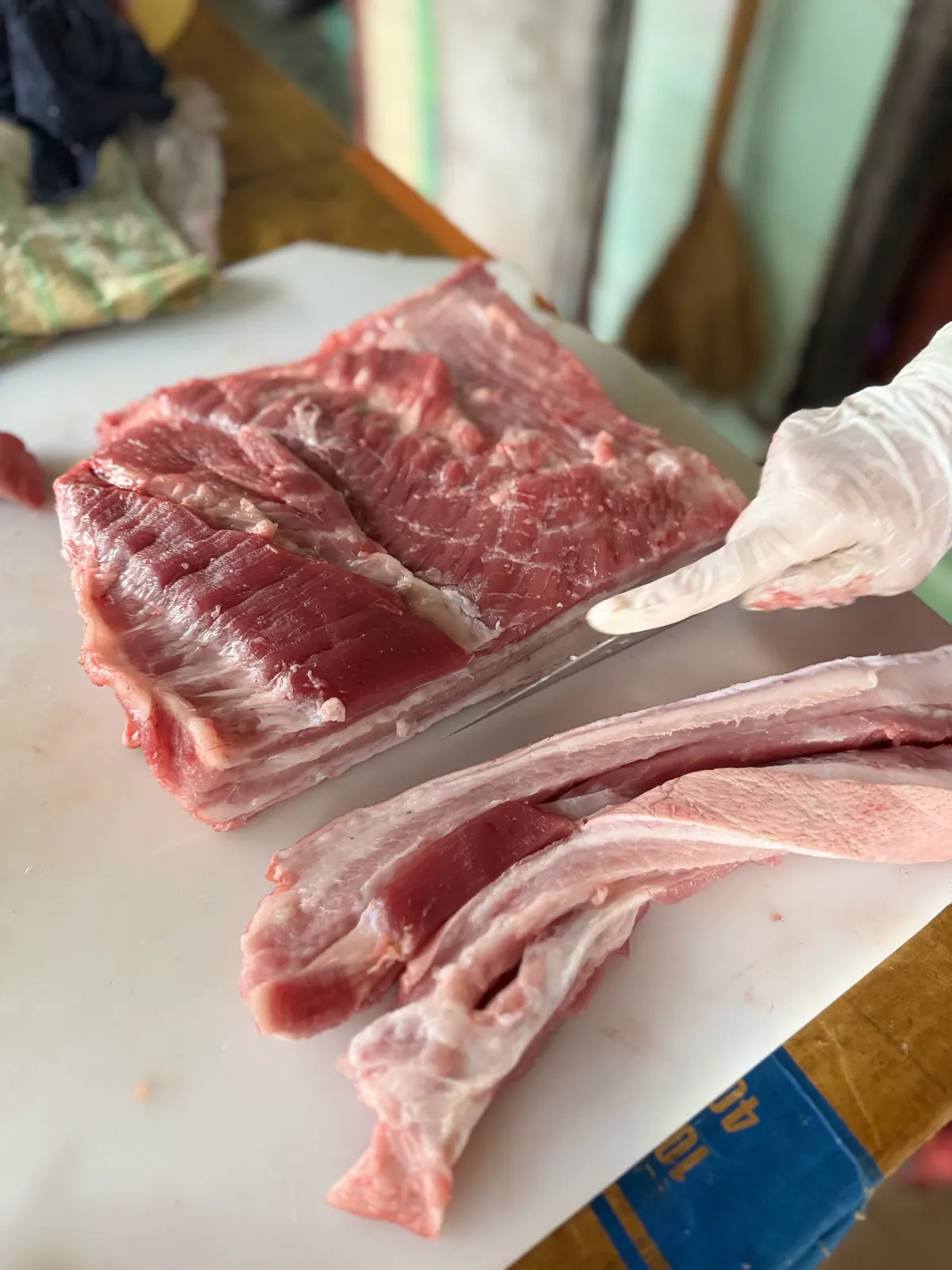 Miếng ba rọi tươi đang được cắt trên thớt