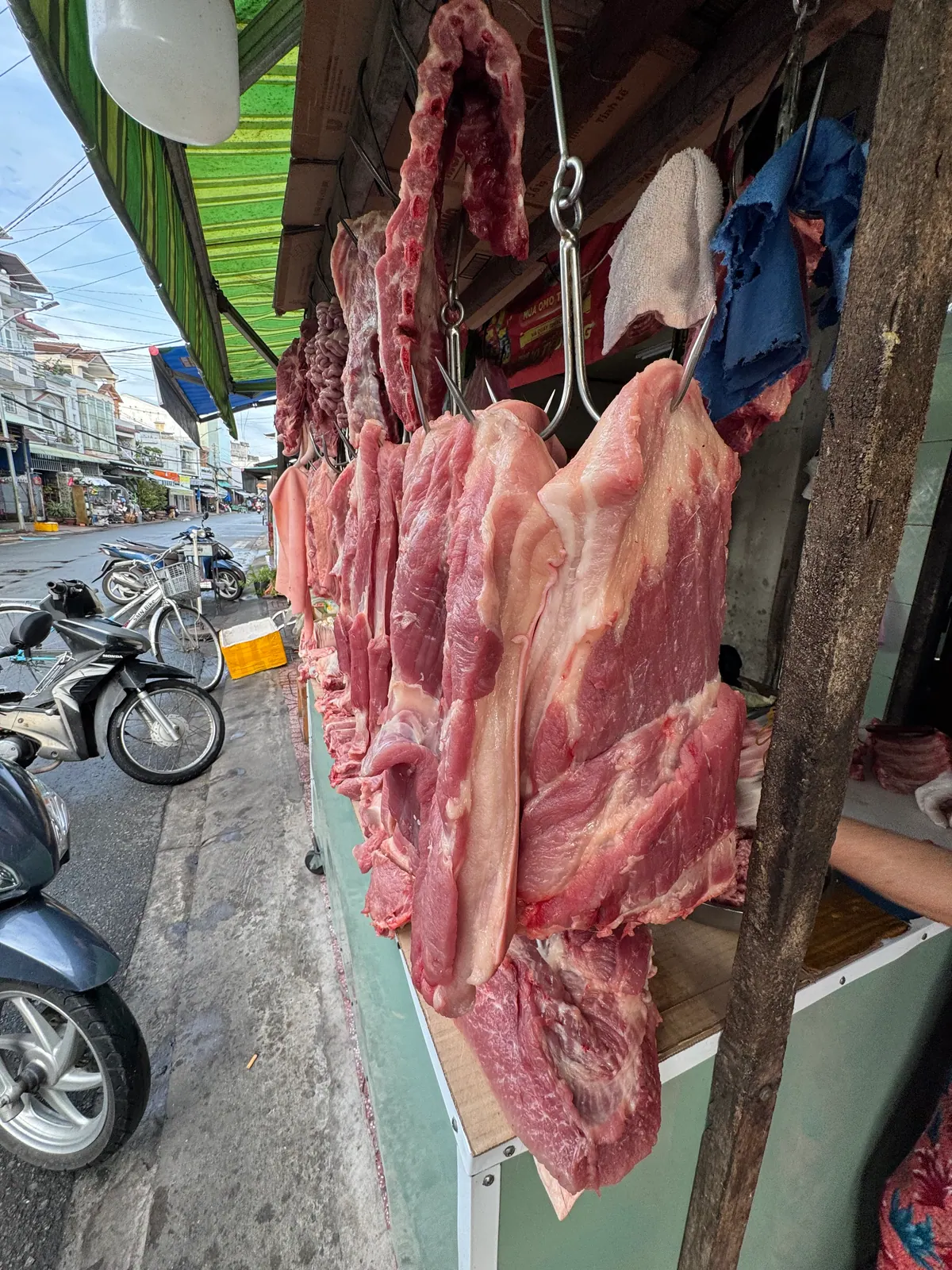 Ba rọi heo tươi treo móc trước sạp